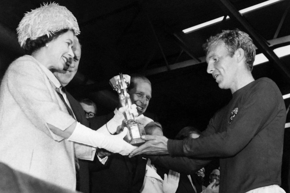 Queen Elizabeth II presents England captain Bobby Moore with the World Cup trophy at Wembley in 1966