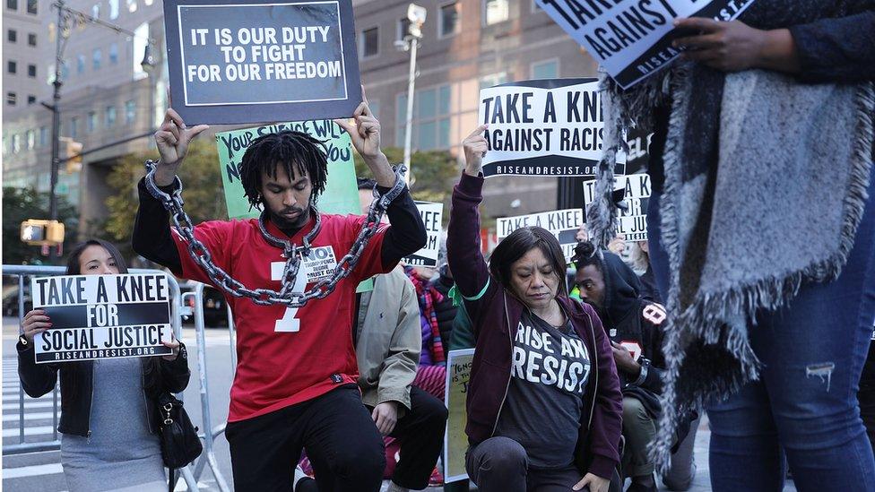 A coalition of advocacy groups 'take a knee' outside of a hotel where members the quarterly NFL league meetings are being held on October 17, 2017 in New York City. Owners, players and commissioner Roger Goodell are all expected to attend.