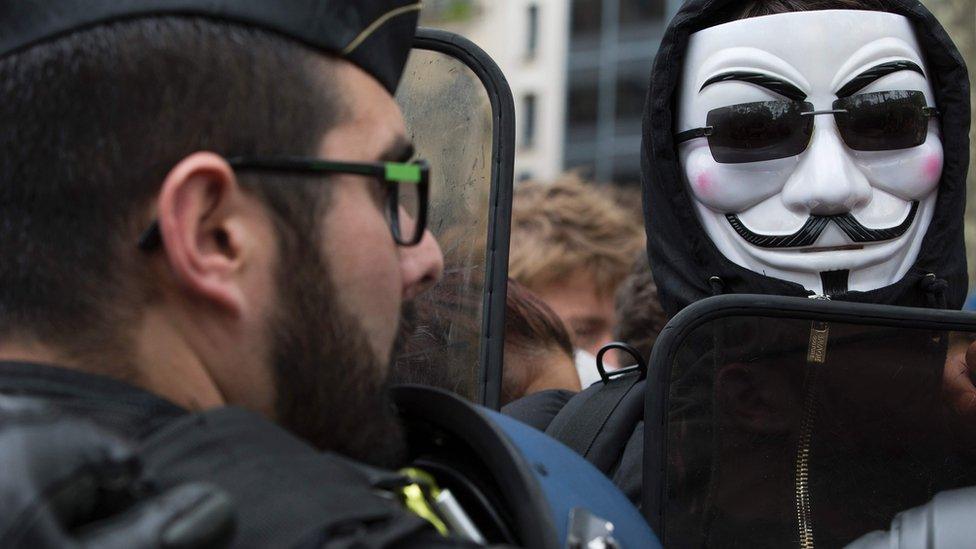 A demonstrator wearing a Guy Fawkes mask looks on as part of a counter-demonstration to a rally of police officers against "anti-police hatred" on May 18, 2016 in Paris