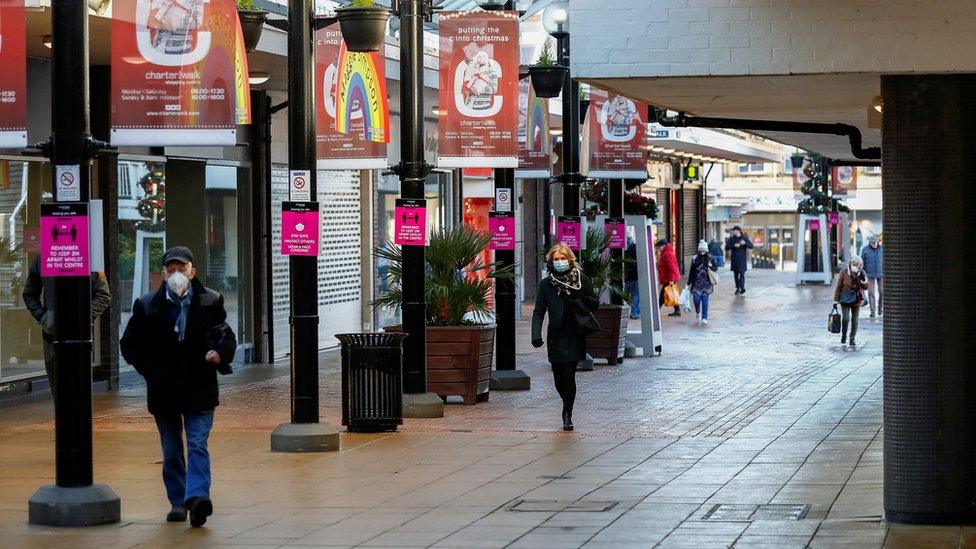 People walk in the town centre of Burnley amid the outbreak of the coronavirus disease