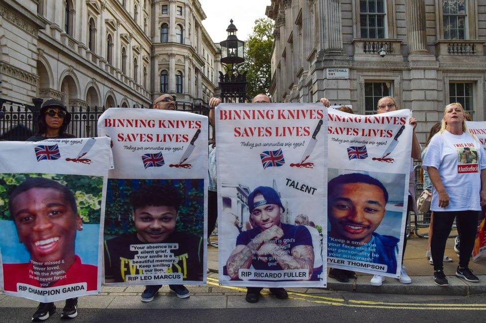 Activists hold pictures of victims of knife crime during the demonstration outside Downing Street