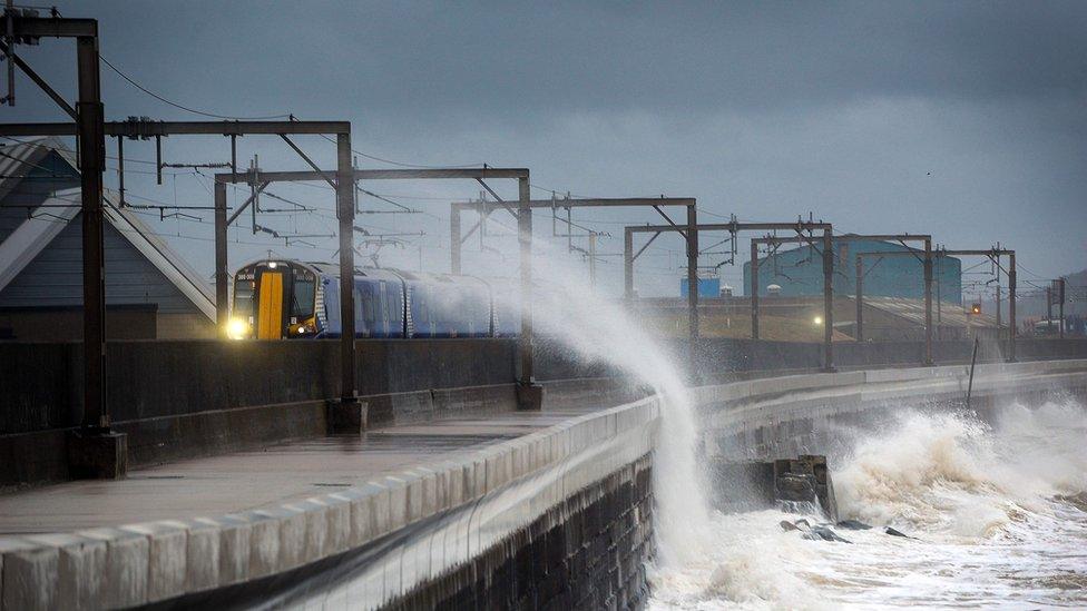 Train passes through waves at Saltcoats in North Ayrshire