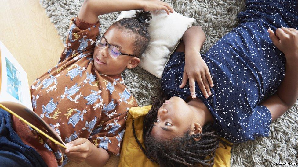 Two boys reading a book