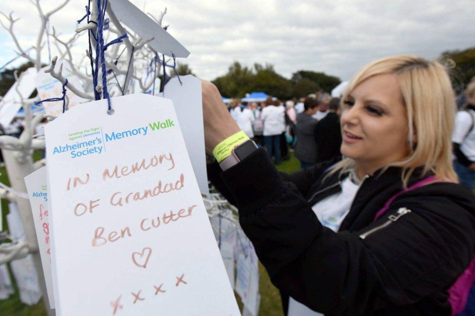 A Memory Walk participant with a written tribute to a loved one