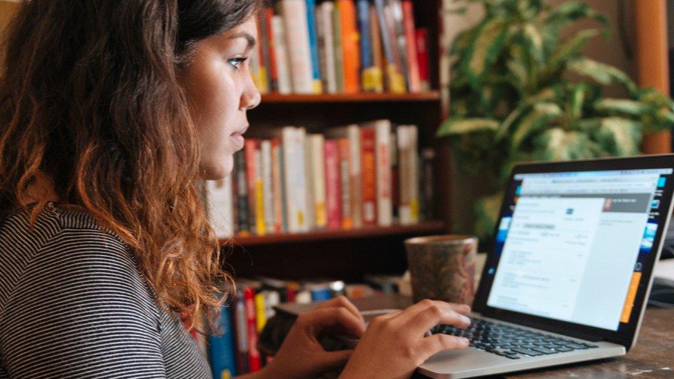 A woman taping at a computer