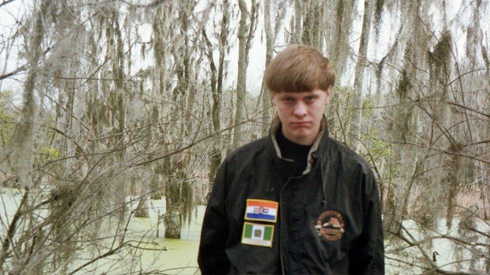 Dylann Roof with flags from apartheid-era South Africa and Rhodesia on his jacket