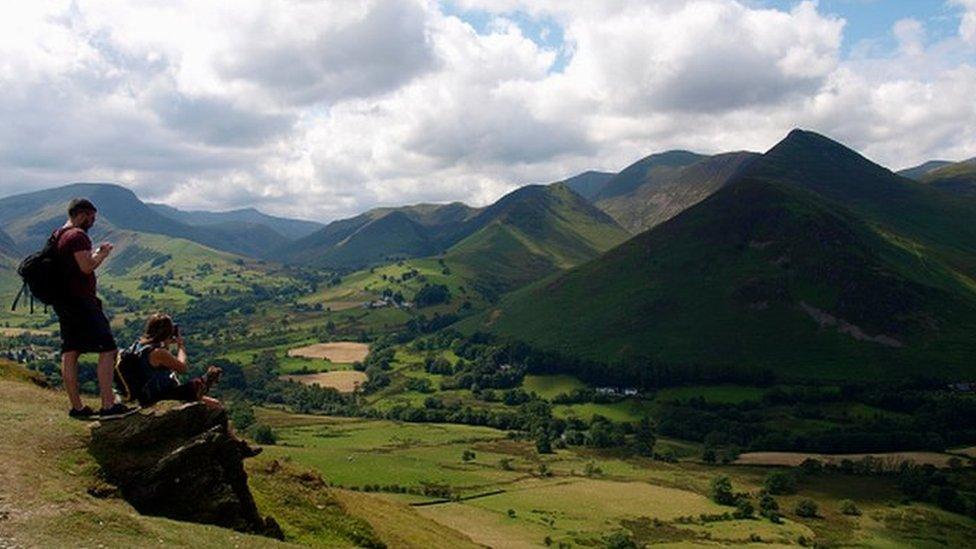 Two people on Cumbria mountains with their phone