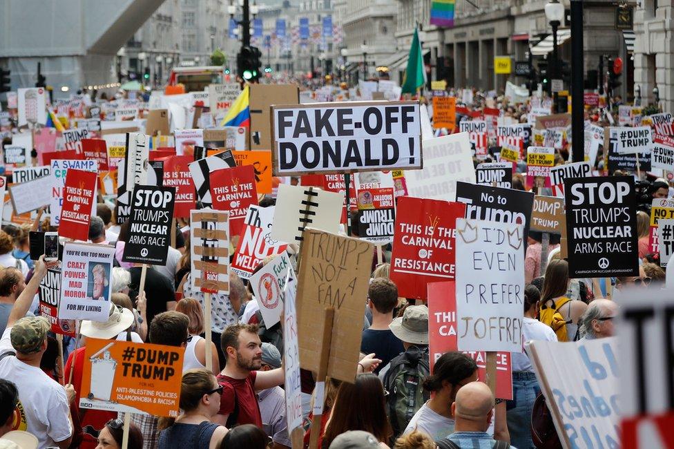 Protesters against the UK visit of US President Donald Trump gather with placards to take part in a march and rally in London