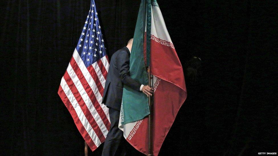 A staff removes the Iranian flag from the stage after a group picture with foreign ministers and representatives of Unites States, Iran, China, Russia, Britain, Germany, France and the European Union during the Iran nuclear talks at the Vienna International Center in Vienna on July 14, 2015.