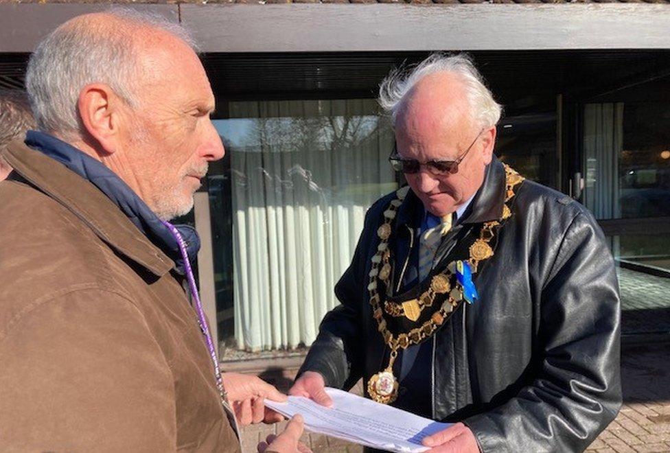 The chairman of Herefordshire Council, Sebastian Bowen, receiving the petition