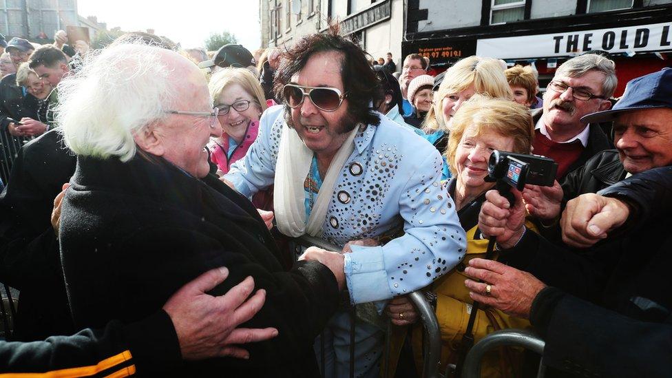 President Michael D Higgins is greeted by Myles Kavanagh "The Kilkenny Elvis" at the unveiling of a statue of the country singer "Big Tom"