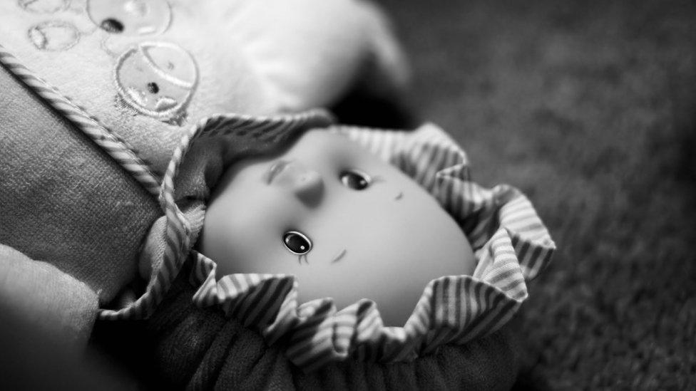 Black and white image of a doll