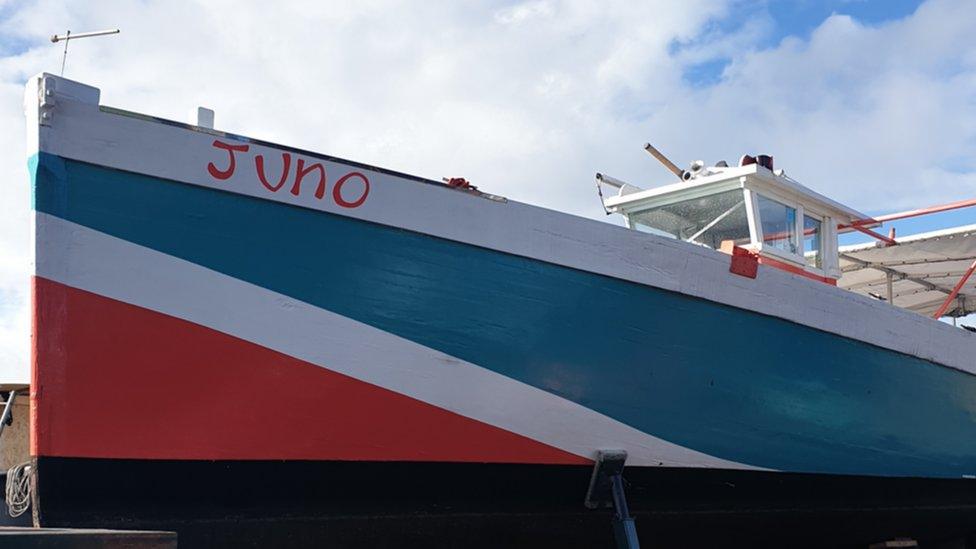 A boat named Juno painted in red and turquoise