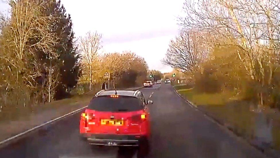 Car blocks road in front of ambulance