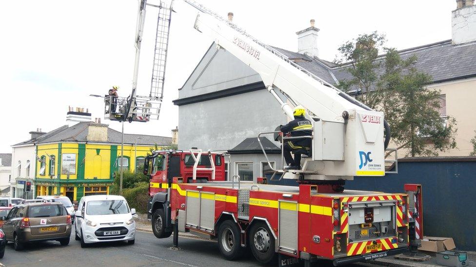 A cherry picker holding the fireman and the rescued puppy