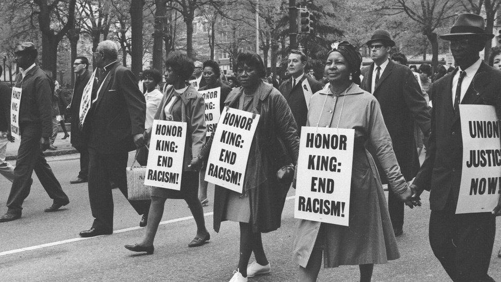 Black and white protesters with placards campaigning for civil rights