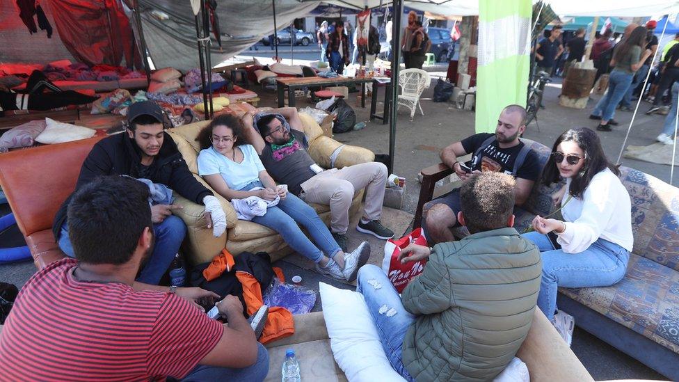 People sit down at an anti-government protest camp in the centre of Beirut, Lebanon (30 October 2019)