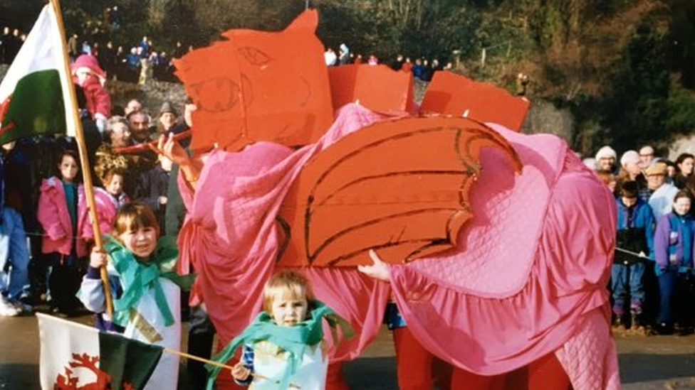 Plant Dai wnaeth wisg y ddraig goch ar ddiwrnod Nadolig 1999. Rhedodd y ddraig goch i mewn i'r môr ar draeth Dinbych-y-pysgod y diwrnod canlynol. Roedd plant Dai wrth eu boddau yn rhedeg i'r môr gyda'u tad wrth dyfu i fyny