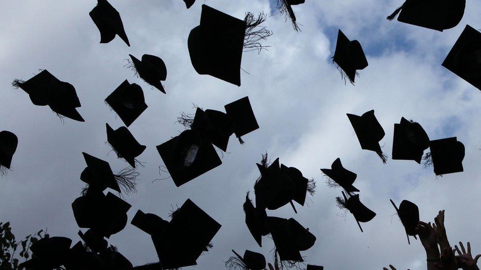 University graduands throw their mortar boards into the air