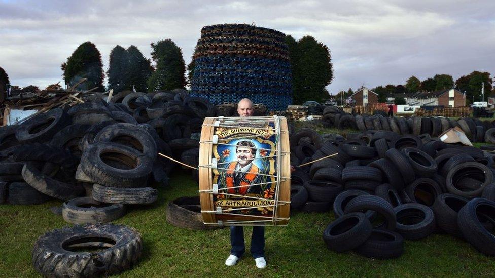 Barry from Kells beats a Lambeg drum in front of the Ballycraigy housing estate bonfire in Antrim, County Antrim.