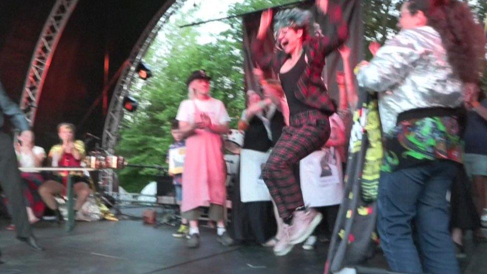 person jumping with colourful mullet