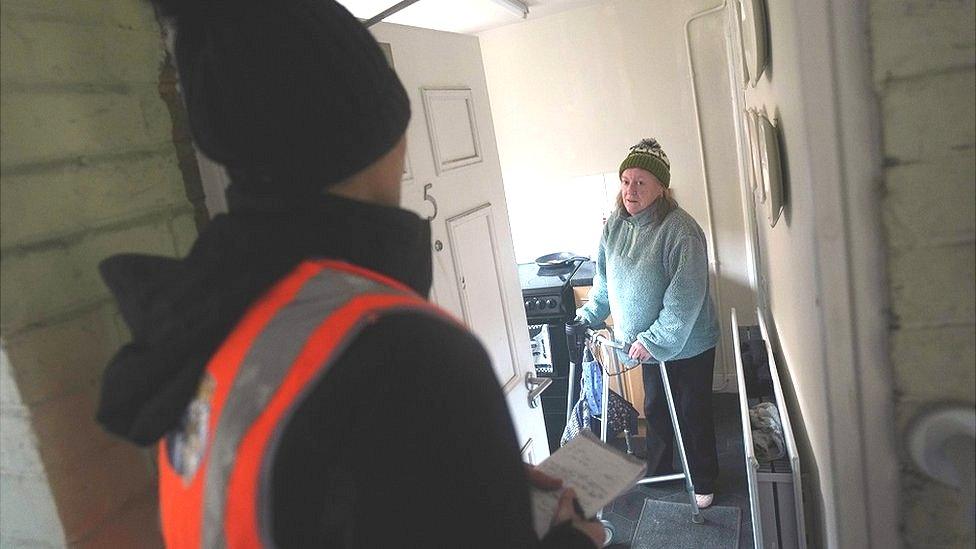 An official talks to a resident affected by Storm Arwen