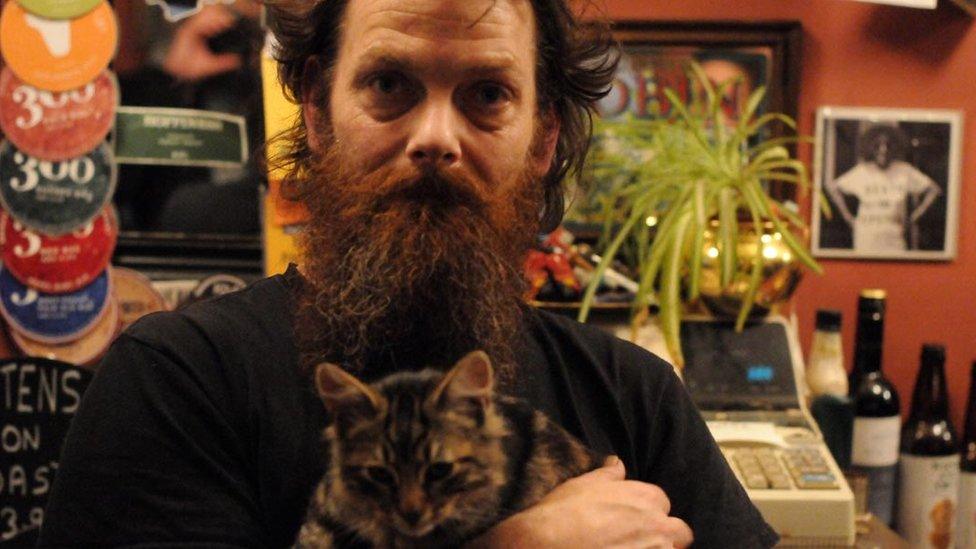 Landlord Luke Daniels with a cat in the Bag of Nails Pub in Bristol