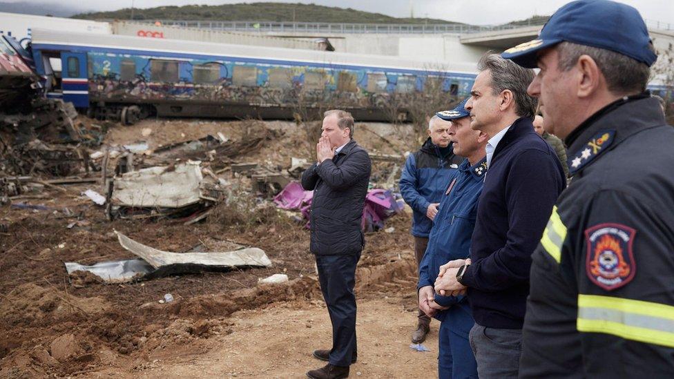 Greek transport minister Kostas Karamanlis (L) and prime minister Kyriakos Mitsotakis (second from right) at the train crash scene