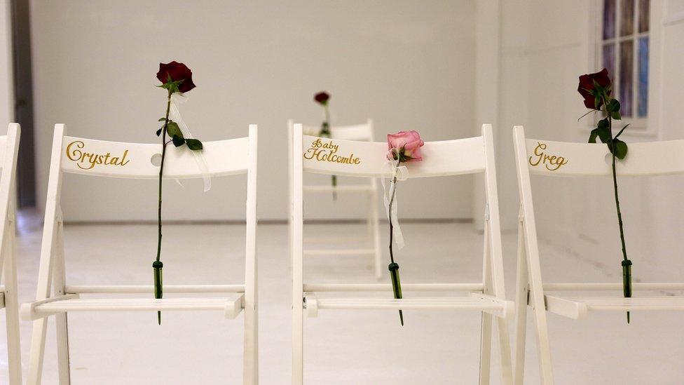 Three white chairs with the names of those killed