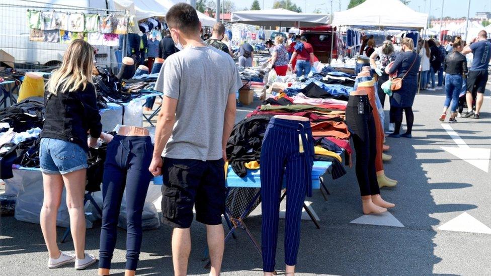 Shoppers check merchandise on sale as a market reopens for trade, in Rzeszow, south east Poland, 10 May 2020