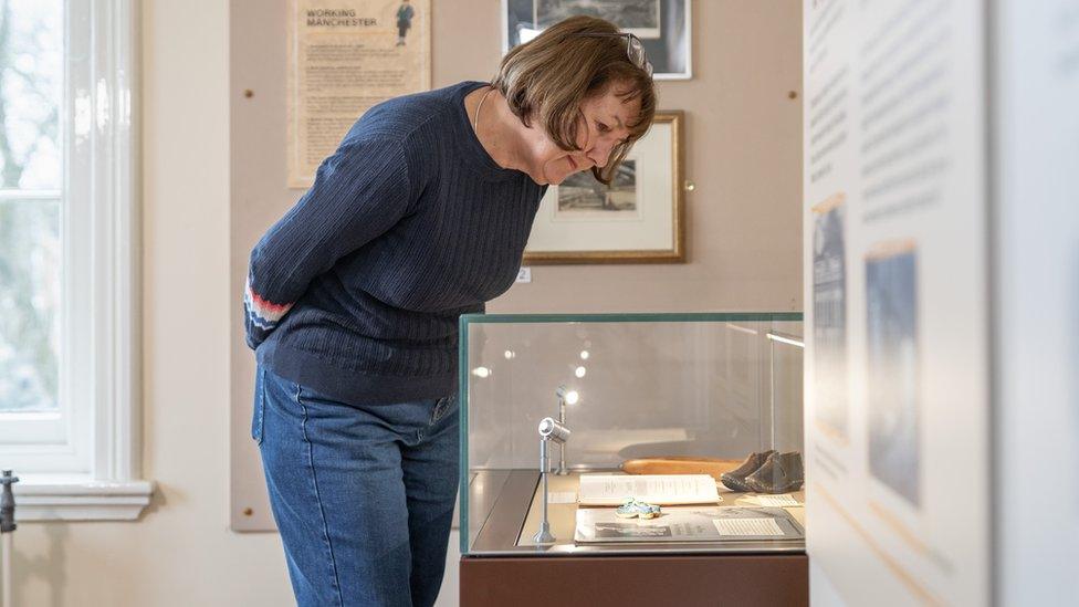 Woman looks at artefacts in Elizabeth Gaskell exhibition