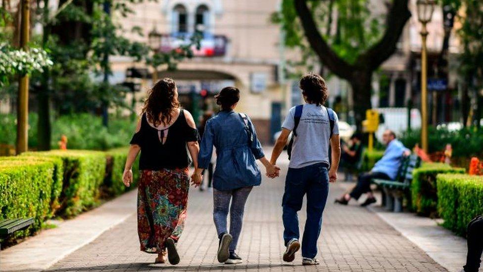 Three people holding hands