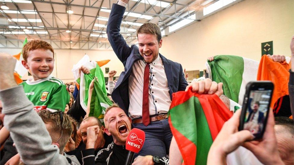 Sinn Fein's Donnchadh Ó Laoghaire celebrates being the first TD elected to the 33rd DÃ¡il, topping the poll ahead of Micheál Martin in cork