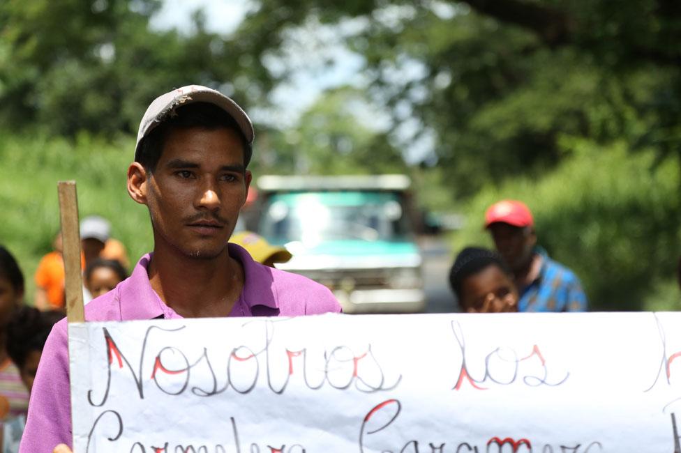 Young man at the roadblock erected by people who have been surviving on mangoes alone