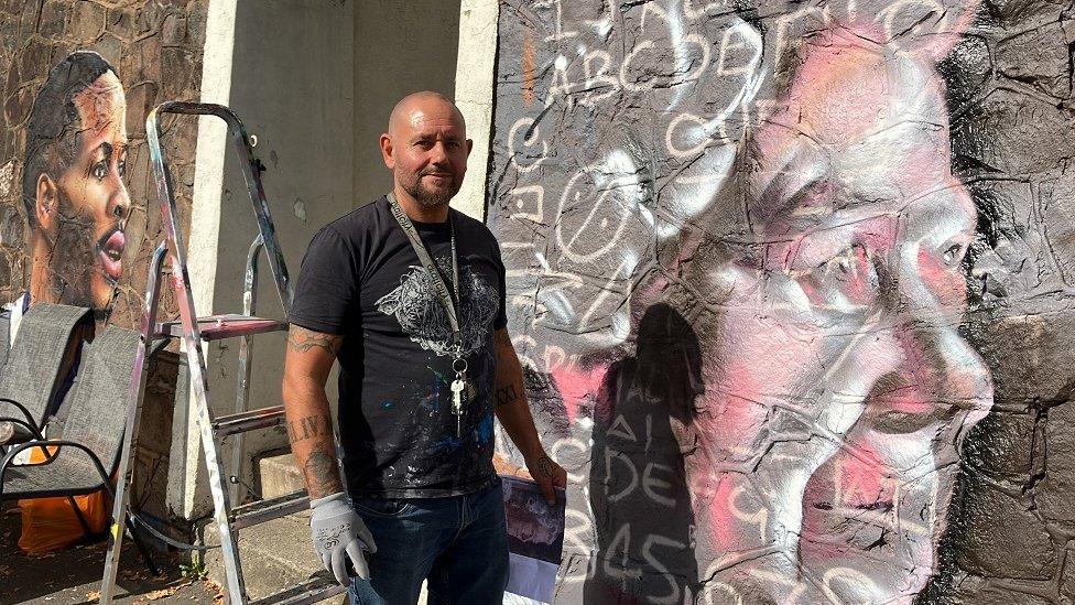 Andy Mills next to the mural