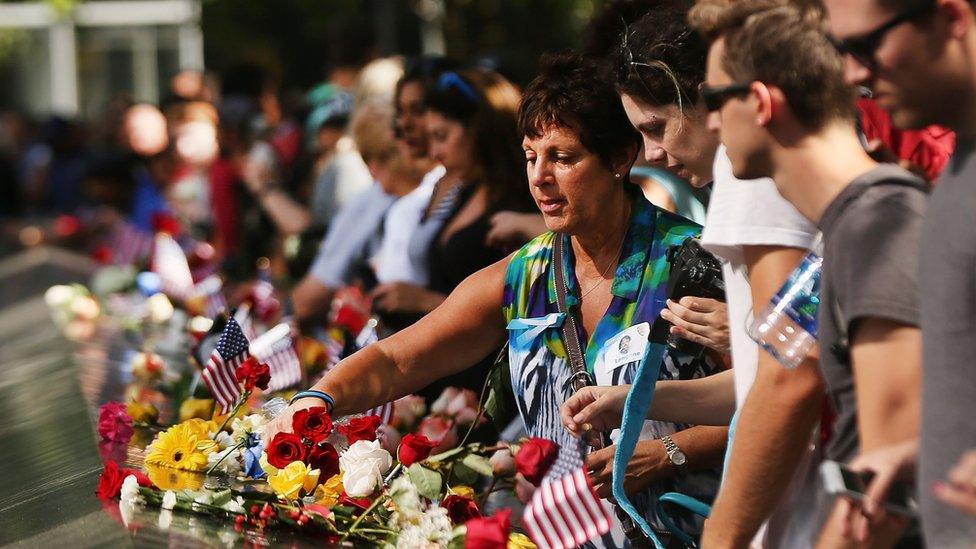 People gather at one of the pools at the National September 11 Memorial following a morning commemoration ceremony for the victims of the terrorist attacks fifteen years after the day on September 11, 2016 in New York City.