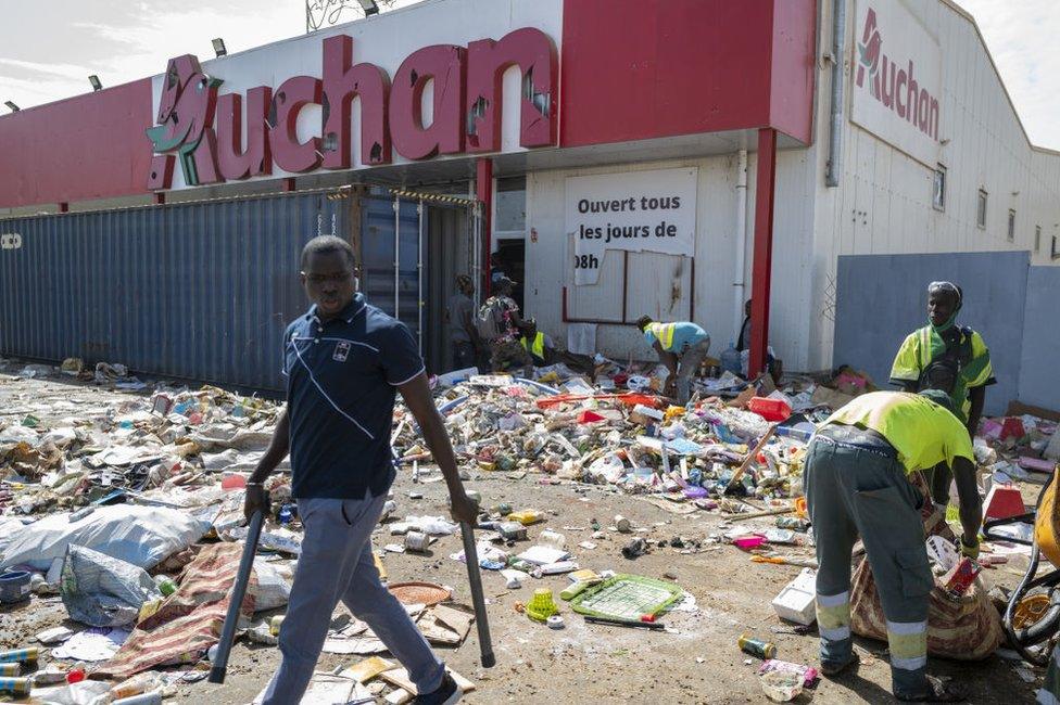 Shop owners clean their shops damaged by protesters during demonstrations after Senegal's opposition leader Ousmane Sonko was taken into custody after court hearing, on March 06, 2021 in Dakar, Senegal.