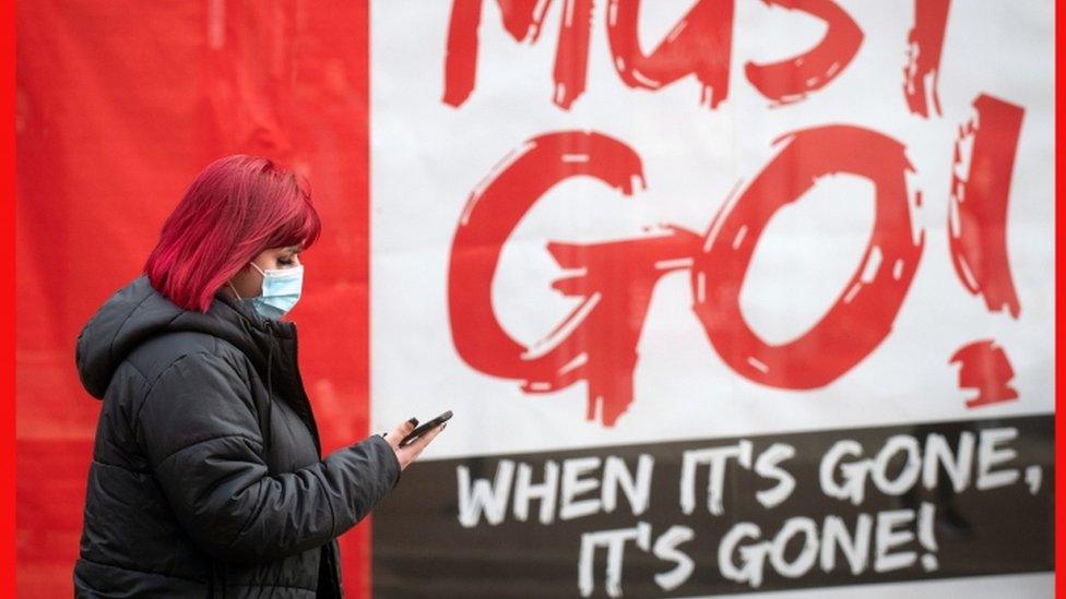 woman-walking-past-sign.