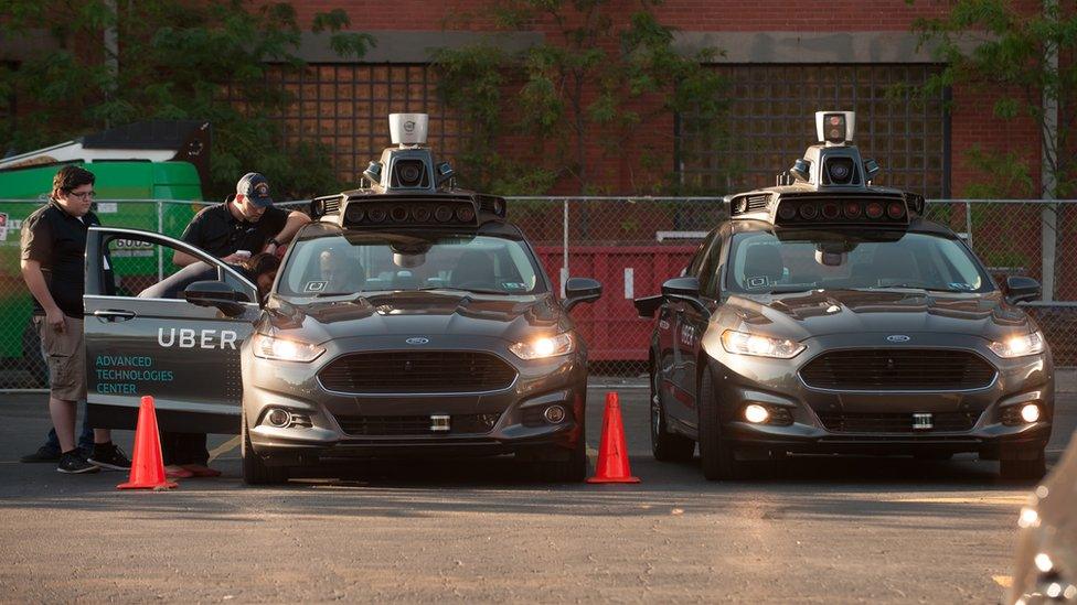 Uber driverless cars and crew members