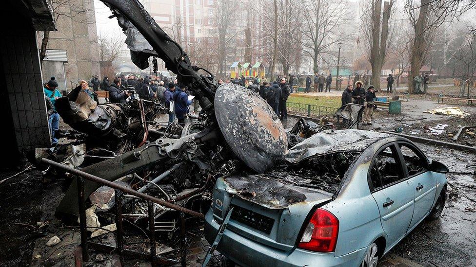 Wreckage of a helicopter rotor lying on a damaged car