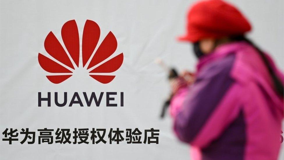 Woman next to Huawei sign