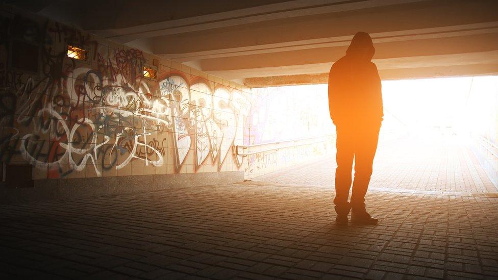 A man standing in an underpass