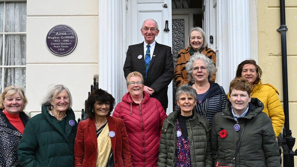 The grandson and granddaughter of Annie Hughes Griffiths alongside the Vice Chancellor of Aberystwyth University, the Health Minister, Eluned Morgan MS, and members of the Wales Purple Plaque Committee