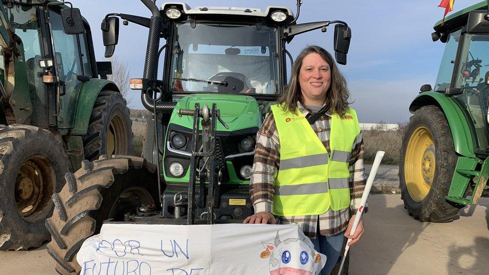 Estrella Pérez standing in front of a tractor