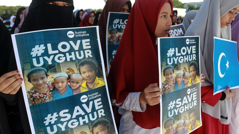 Uighur protesters in Indonesia in 2018 hold signs reading #LoveUyghur and #SaveUyghur