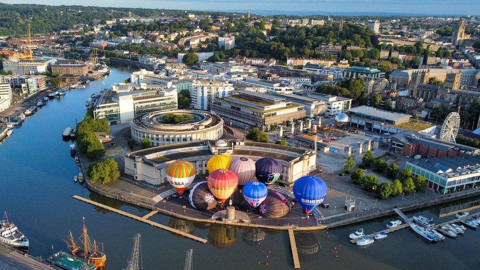 Hot air balloons inflate and tether from Bristol Harbourside as the countdown begins to the 2023 Bristol International Balloon Fiesta at Ashton Court Estate in August.