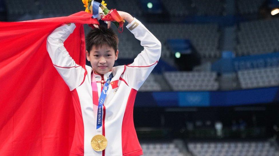 Gold medalist Quan Hongchan of China poses with a Chinese national flag during the medal ceremony for the Women's 10m Platform Final