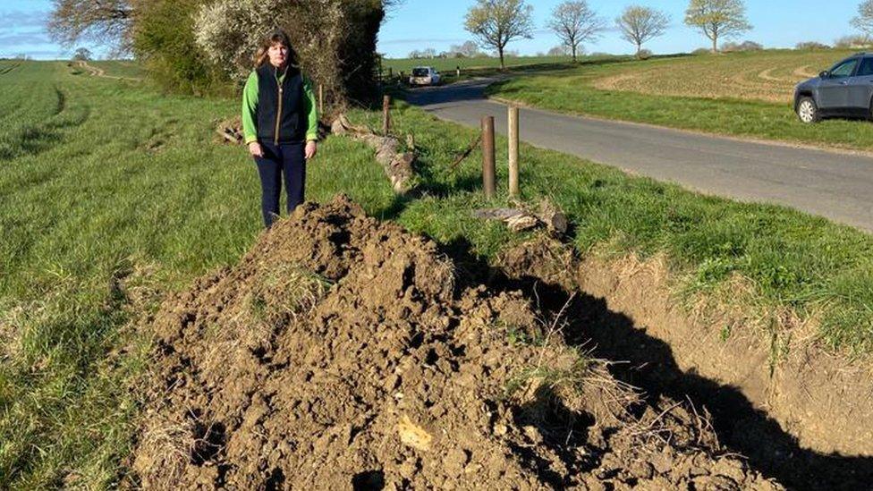 Freya Morgan beside half-dug ditch