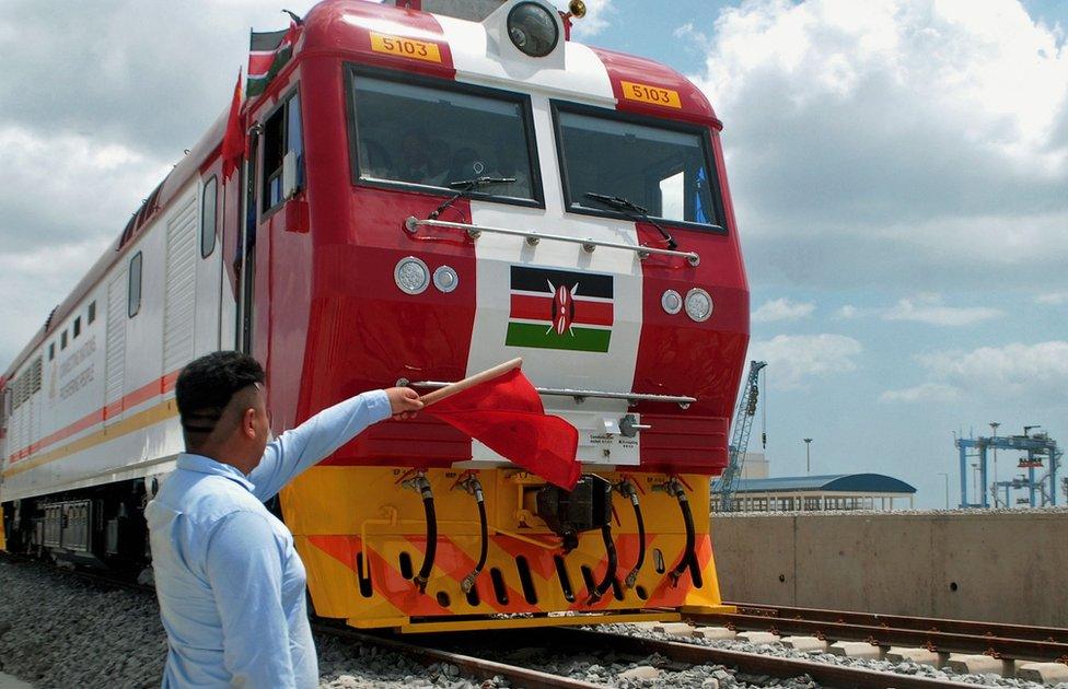 Man waving a red flag during the launch of the first batch of Standard Gauge Railway freight locomotives at Mombasa Port - January 11, 2017