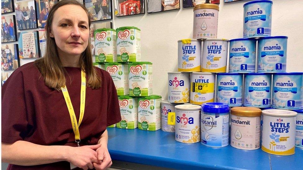 Dee Denton from KidsBank with tins of infant formula